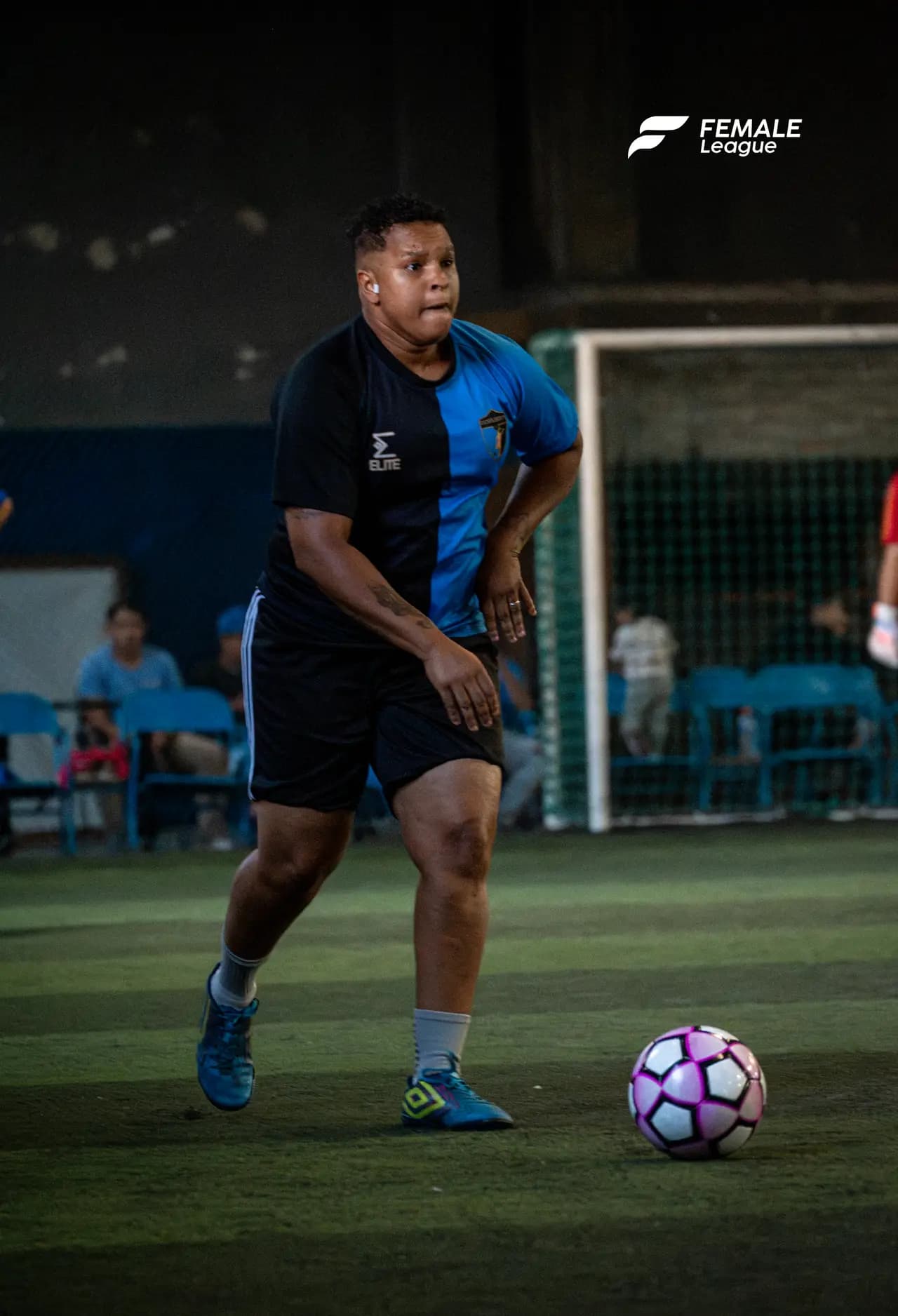Jugadora conduciendo la pelota en cancha nocturna de Female League