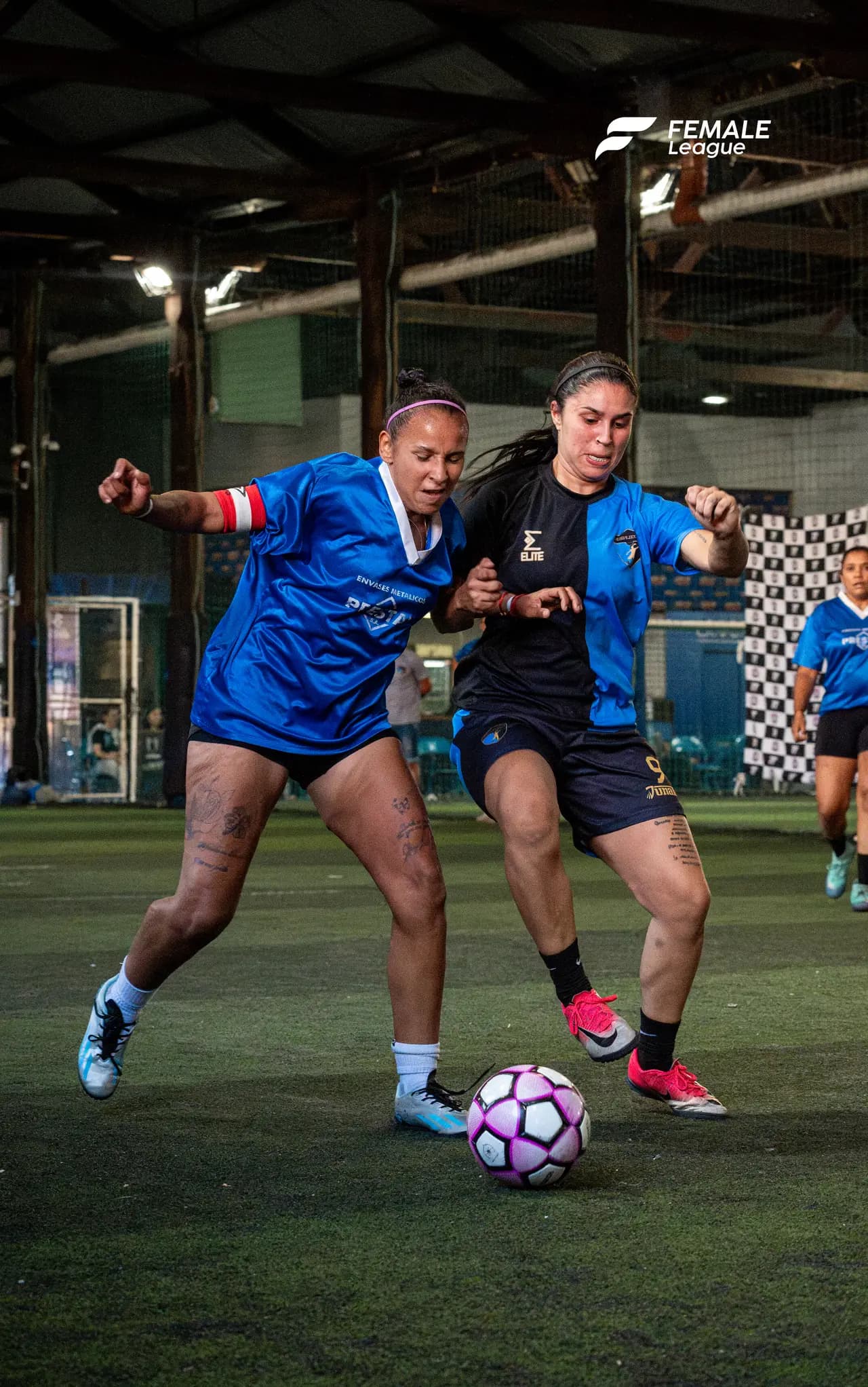Dos jugadoras disputando la pelota cuerpo a cuerpo en partido nocturno